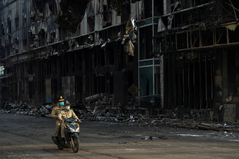 Пойпет, Камбоджа. Полицейские проезжают мимо сгоревшего отеля-казино Grand Diamond City 