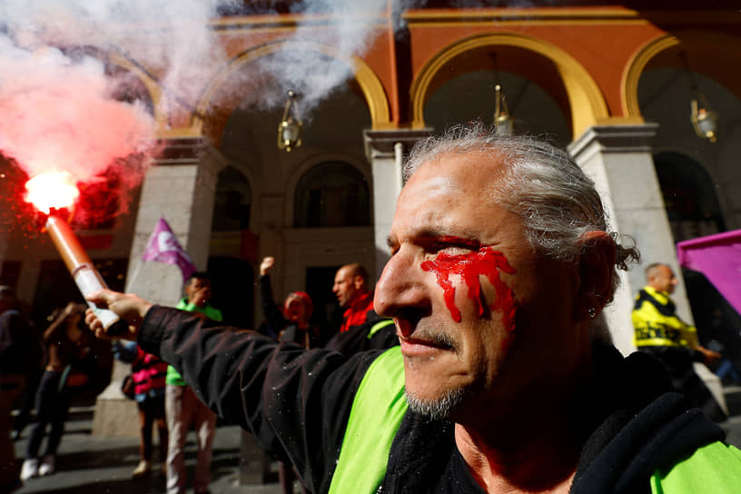 Демонстрант с красной краской на лице в Ницце 