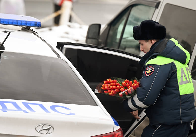 Сотрудник ДПС с букетом тюльпанов у Рижского рынка