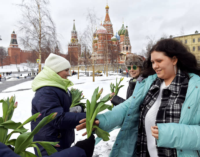 Волонтеры раздают цветов женщинам в московском парке «Зарядье»