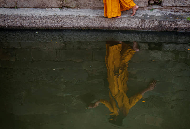 Катманду, Непал. Местная жительница возвращается по берегу реки Багмати с однодневного фестиваля Мататиртха Аунши, посвященного умершим матерям 