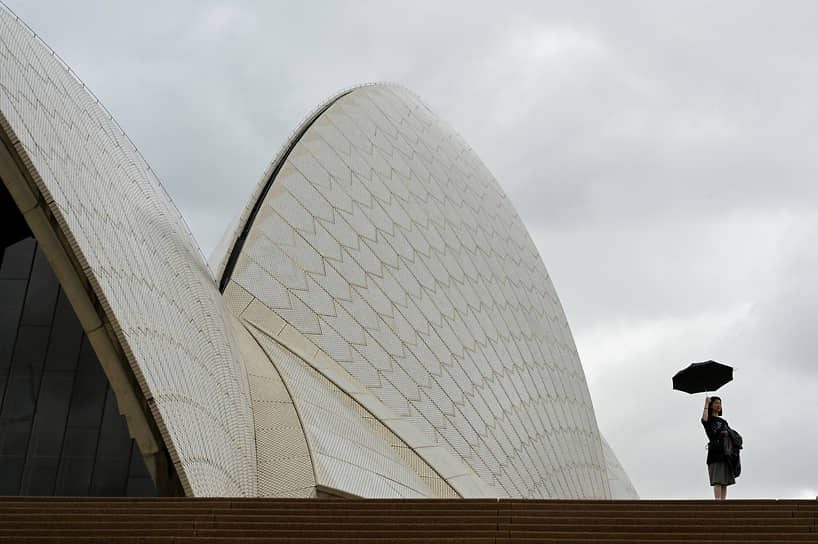 Сидней, Австралия. Женщина с зонтом стоит у Сиднейского оперного театра