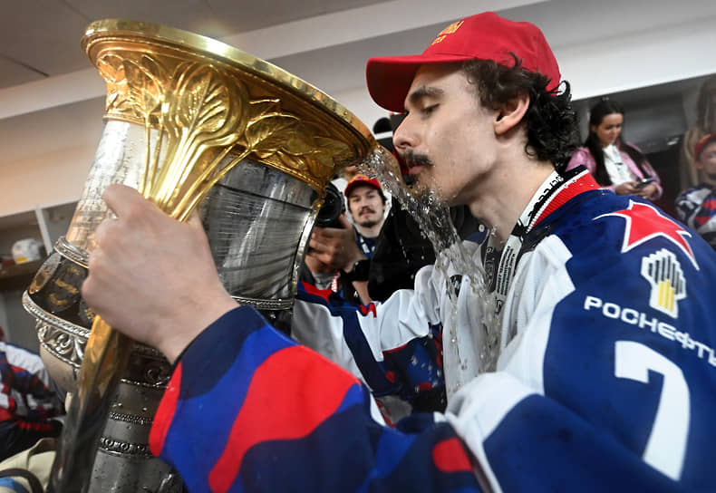 Нападающий ЦСКА Матвей Гуськов держит трофей, наполненный шампанским