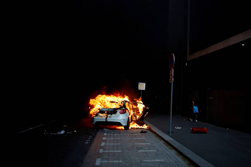 Нантер, Франция. Горящий автомобиль на фоне уличных беспорядков