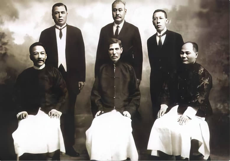Сэр Роберт Хотун (сидит, в центре) с братьями и знакомыми. Сидят: совладелец банка Dayou Лиу Чжубо (слева), Хо Ком Тон (справа). Стоят, слева направо: Хо Фук, Хэ Ганьтан, совладелец банка Dayou Ло Чэун Шиу