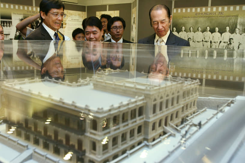 Стэнли Хо (справа) рассматривает модель Куинз-колледж, учебного заведения, в котором учился он и другие члены клана Хо