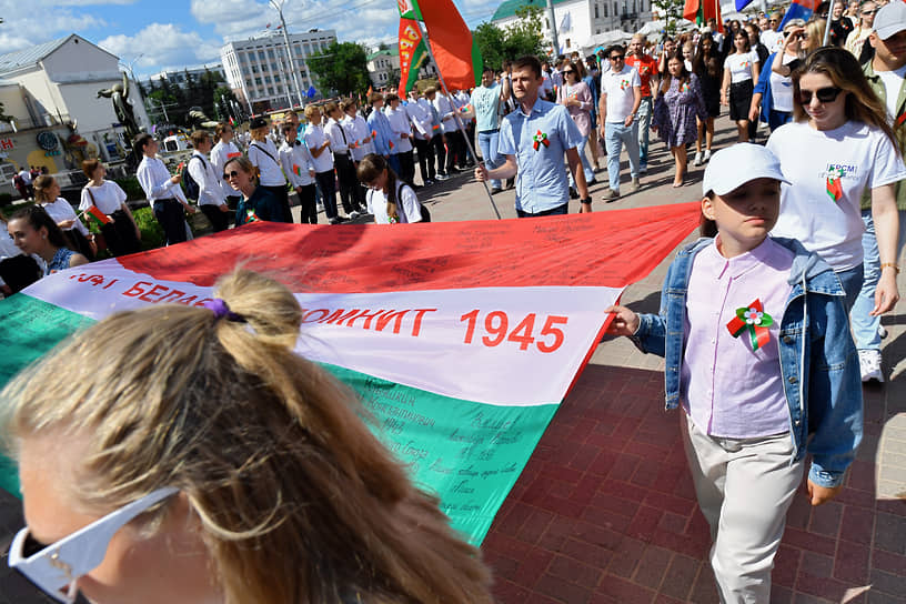Участники фестиваля разворачивают флаг Белоруссии