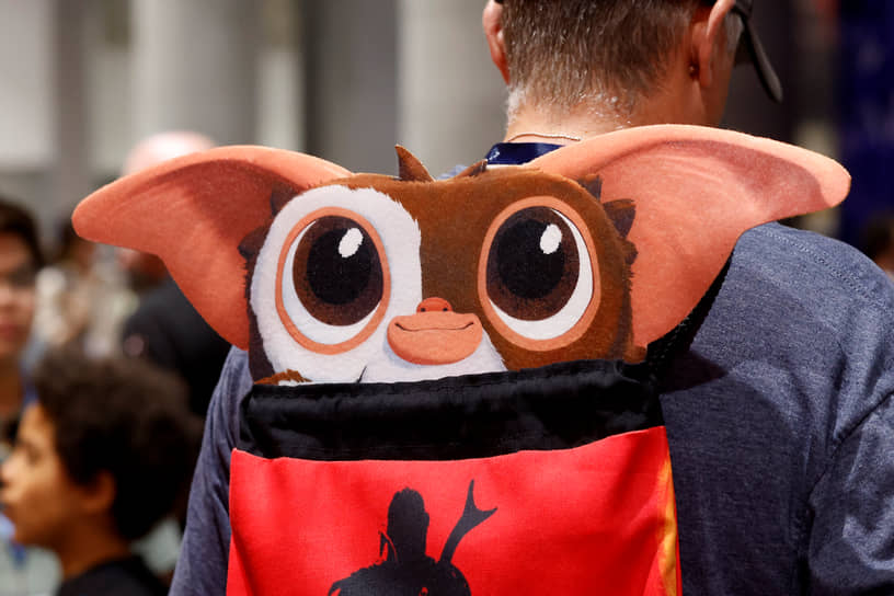 Посетитель Comic-Con с рюкзаком в виде гремлина