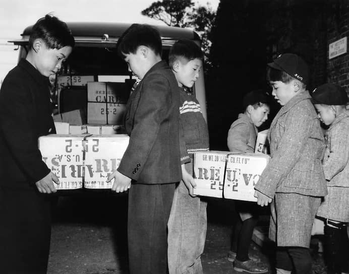 Японские школьники разгружают ящики с гуманитарной помощью CARE