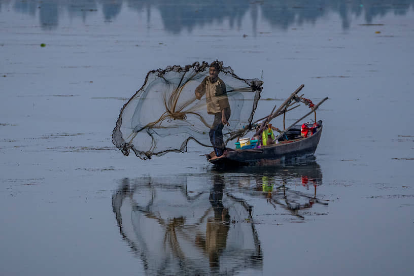 Срингар, Индия. Кашмирский рыбак забрасывает сети в воды озера Дал 