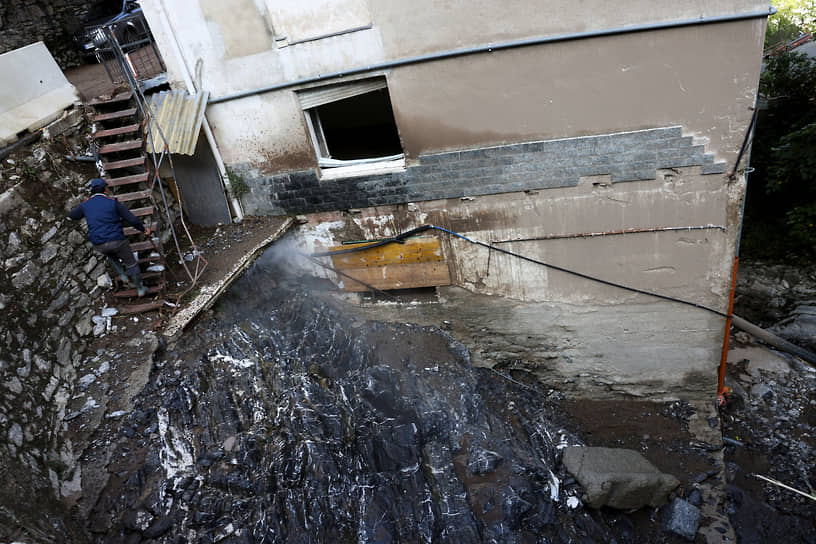 Блевио, Италия. Местный житель поднимается по лестнице дома, пострадавшего от оползня