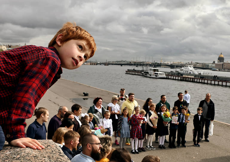 Школьники фотографируются с родителями на набережной в Санкт-Петербурге