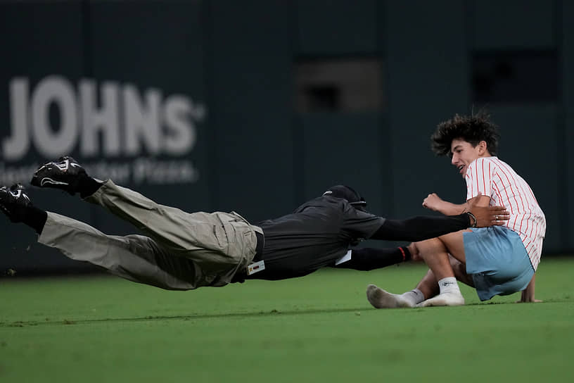 Атланта, США. Охранник задерживает болельщика, выбежавшего на поле во время бейсбольного матча между командами «Сент-Луис Кардиналс» и «Атланта Брэйвз»

