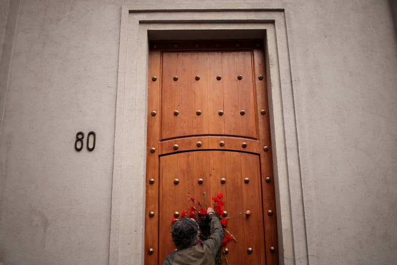 Сантьяго. Человек возлагает венок на дверь резиденции президента Чили в день 50-й годовщины военного переворота 