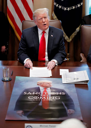 45-й президент США Дональд Трамп сидит перед плакатом в стиле «Игры престолов» с надписью «Санкции близко»