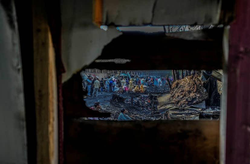 Сринагар, Индия. Местные жители смотрят на последствия пожара, уничтожившего около десятка хижин