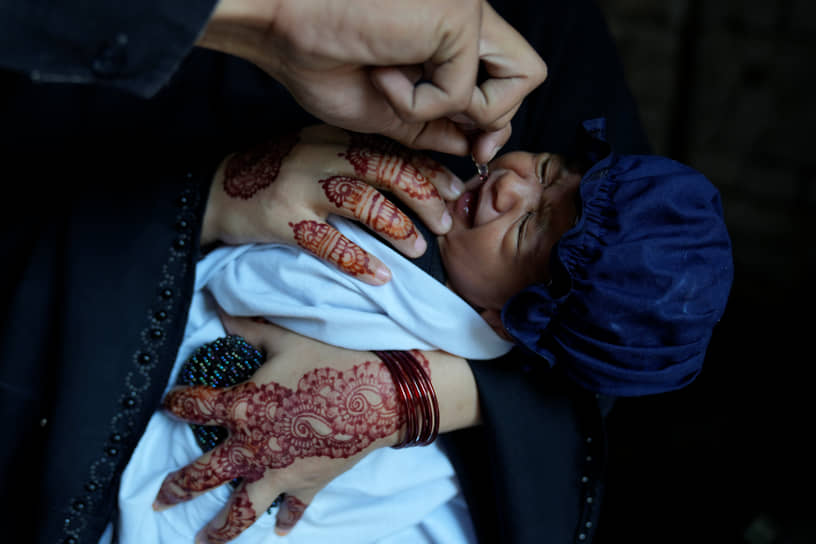 Лахора, Пакистан. Новорожденного ребенка вакцинируют от полиомиелита
