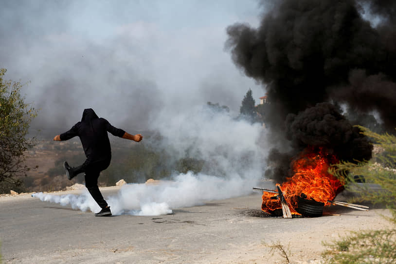 Тулькарм, Палестина. Протестующий пинает баллончик со слезоточивым газом во время столкновений с израильскими силовиками