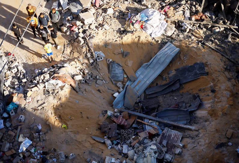 Палестинцы осматривают место израильского удара по дому в Рафахе на юге сектора Газа