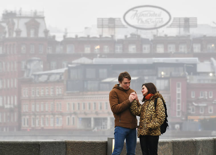 Москва. Пара стоит на мосту во время тумана