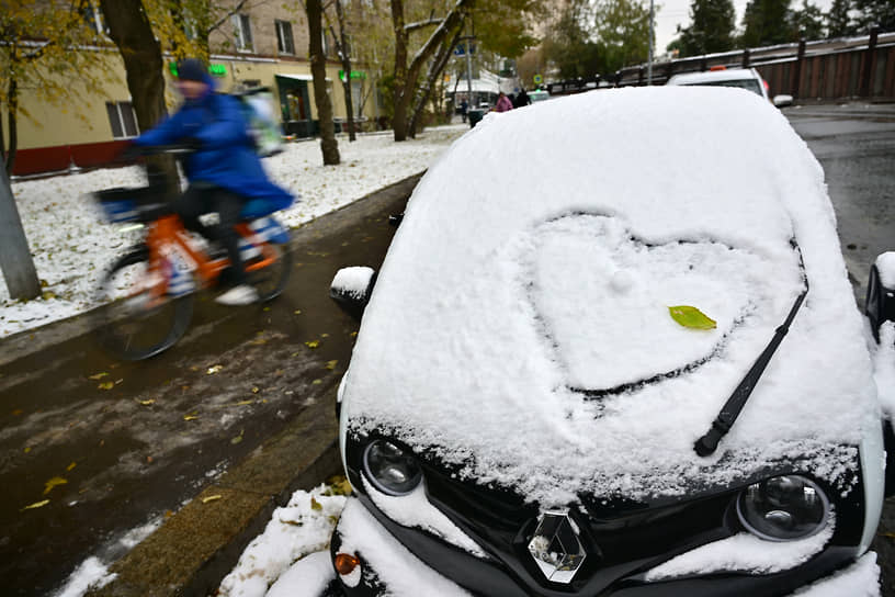 Москва, Россия. Нарисованное сердце на лобовом стекле заснеженного автомобиля