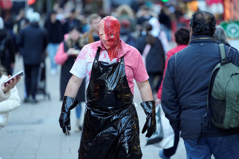 Эссен, Германия. Мужчина в костюме зомби гуляет по торговой улице