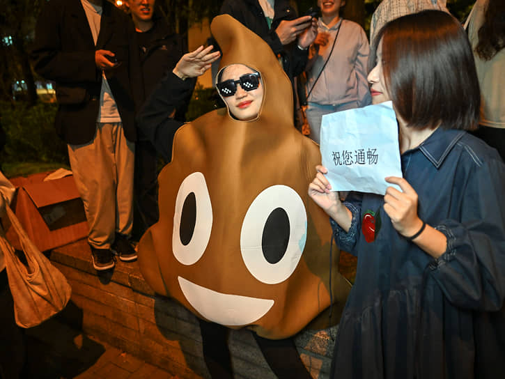 Шанхай, Китай. Гостья парада на Хэллоуин в костюме эмодзи 