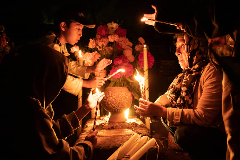 Семьи в честь Дня мертвых украшают могилы родственников цветами и проводят ночь на кладбище, общаясь с усопшими
&lt;br>На фото: празднование в мексиканском городе Ацомпа