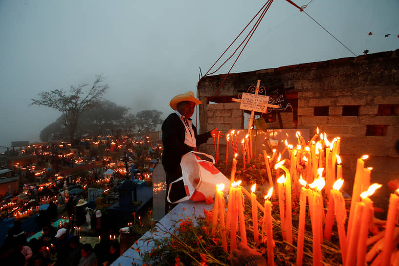 Мужчина на могиле родственника в мексиканском городе Масатлан Вилья-де-Флорес