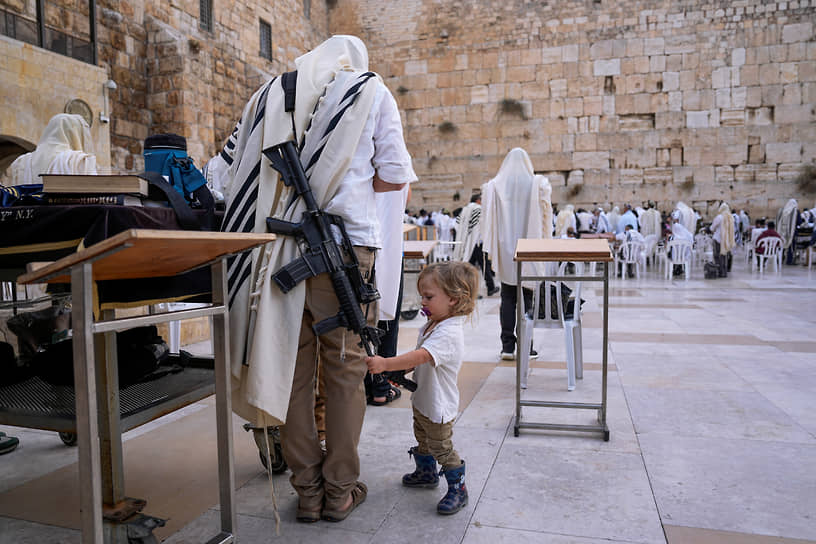 Иерусалим. Сотрудник израильских сил безопасности с ребенком у Стены плача