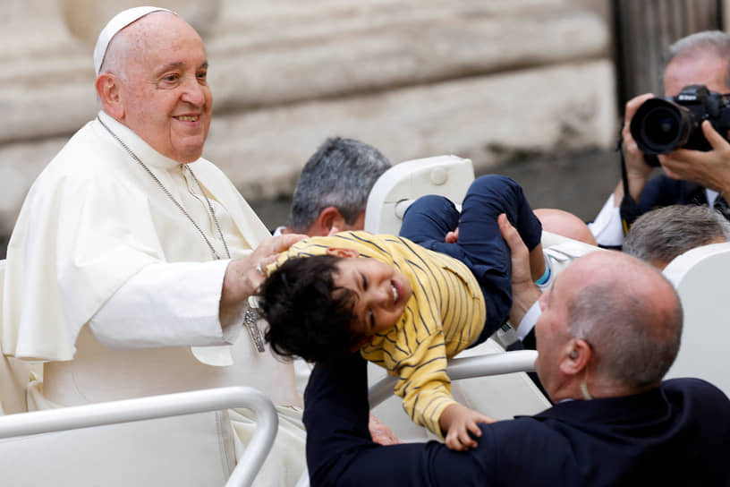 Ватикан. Папа римский Франциск благословляет ребенка, уходя после еженедельной общей аудиенции