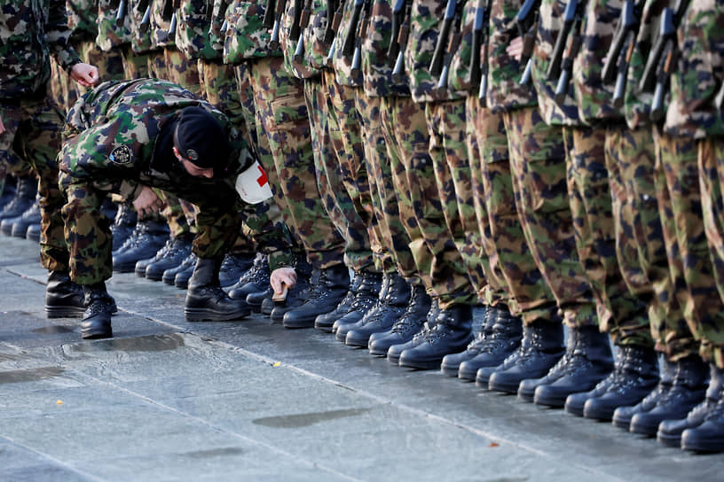 Берн, Швейцария. Солдат чистит сапоги сослуживца перед смотром президентов Швейцарии и Франции Алена Берсе и Эмманюэля Макрона