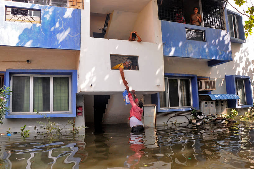 Ченнай, Индия. Волонтер разносит еду жителям домов, затопленных в результате проливных дождей 
