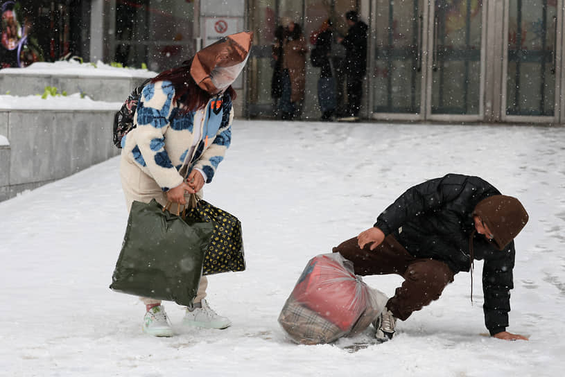 Пекин, Китай. Мужчина падает во время снегопада