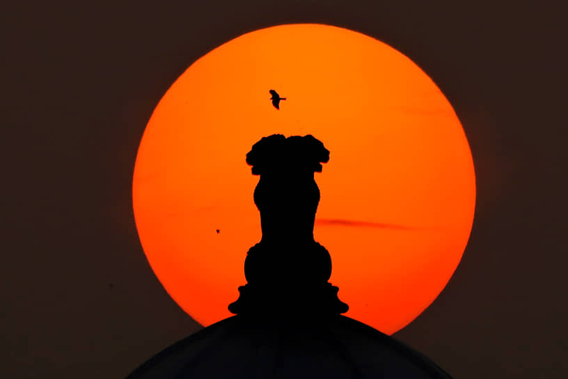 Хайдарабад, Индия. Герб страны, представляющий собой львиную капитель, на фоне заката