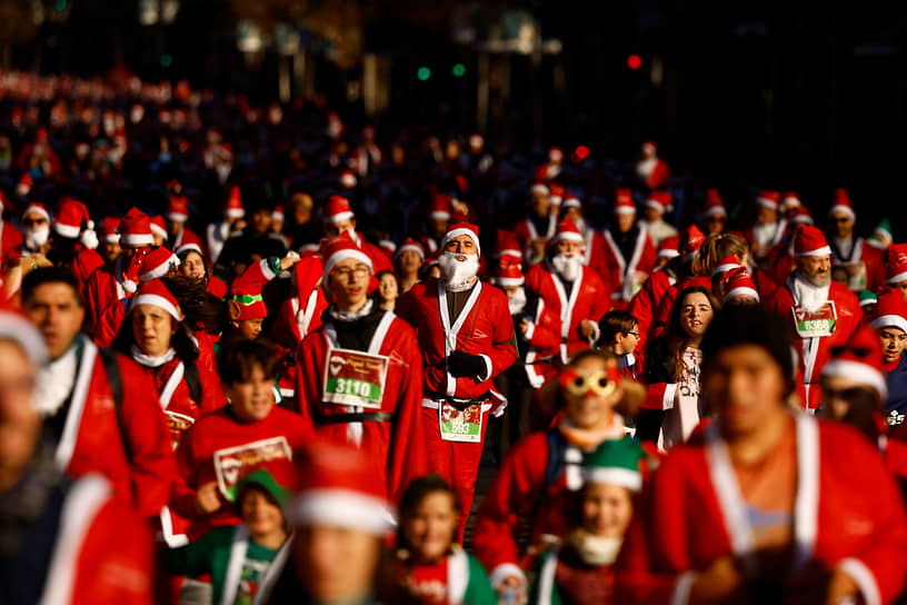 Мадрид, Испания. Люди в костюмах Санта-Клауса принимают участие в благотворительном забеге 