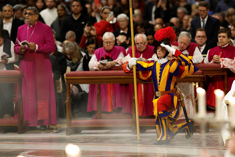 Ватикан. Член Швейцарской гвардии отдает честь на праздновании Рождества в базилике Святого Петра