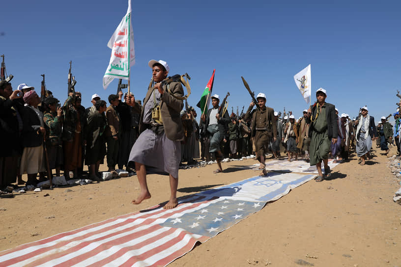 Бани Хушайш, Йемен. Сторонники хуситов маршируют по раскиданным на земле флагам США и Израиля 