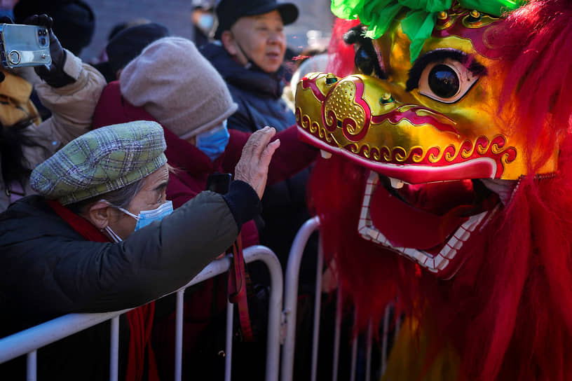 Пекин, Китай. Зрители наблюдают за традиционным танцем льва