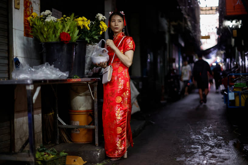 Бангкок, Таиланд. Женщина в традиционном костюме покупает праздничный ужин