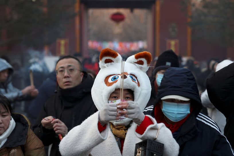 Пекин, Китай. Китайцы зажигают ароматические палочки в  храме Юнхэгун