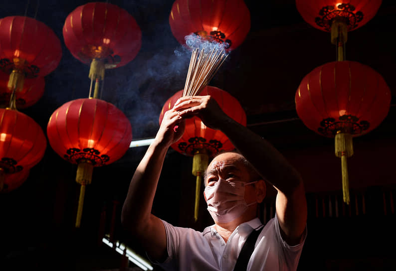 Куала-Лумпур, Малайзия. Мужчина зажигает ароматические палочки в даосском храме Син Сзе Си Я 