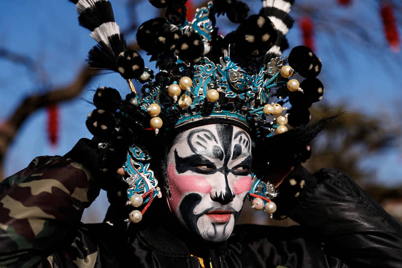 Пекин, Китай. Посетитель храмовой ярмарки в маске