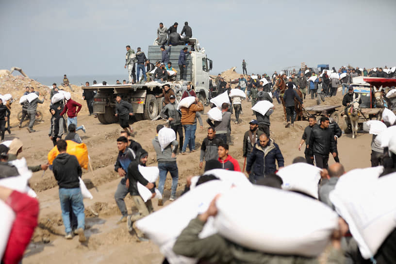 Сектор Газа. Палестинцы с мешками гумпомощи возле контрольно-пропускного пункта на границе с Израилем 

