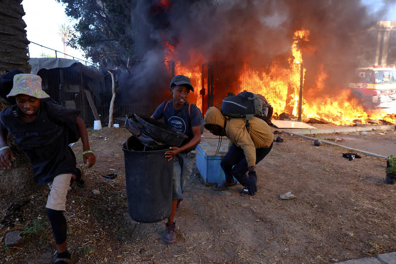 Кейптаун, ЮАР. Люди выносят вещи из горящего палаточного городка