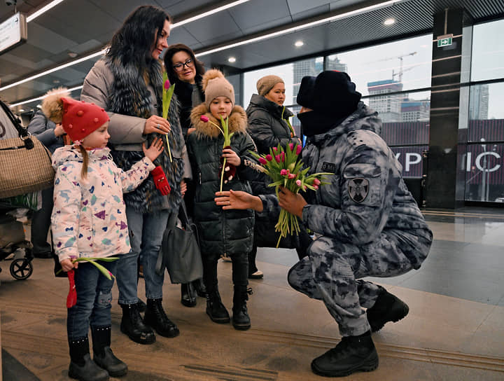 Москва. Полицейский дарит женщинам и детям цветы на станции метро «Мичуринский проспект»