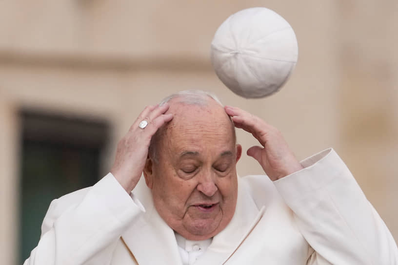 Ватикан. Папа римский Франциск пытается поймать свой головной убор — пилеолус — на еженедельной общей аудиенции 