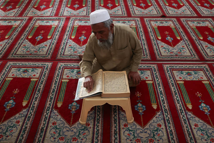 Пешавар, Пакистан. Мужчина читает Коран 