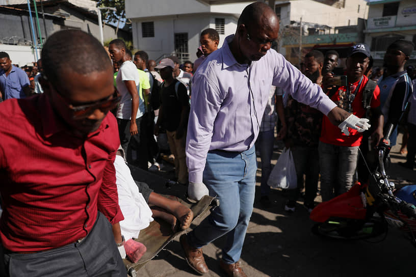 Бандиты атаковали не только президентский дворец, но и несколько правительственных зданий, например, Министерство внутренних дел Гаити &lt;br> На фото: работники мэрии выносят тело погибшего во время стрельбы в Порт-о-Пренсе, март 2024 года