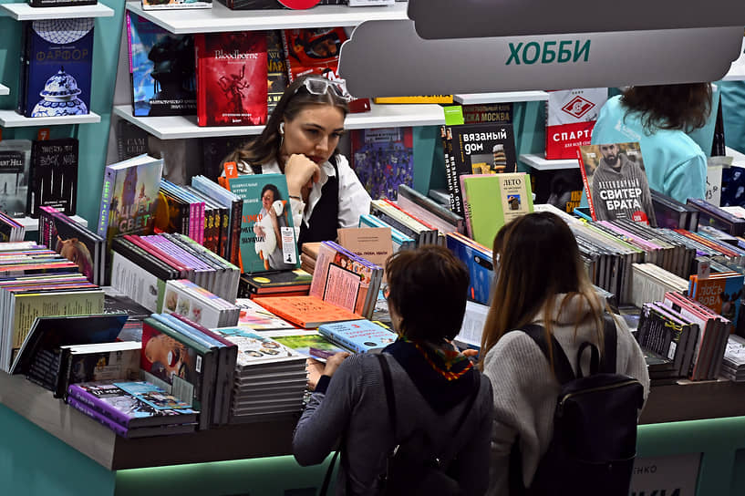 Посетители ярмарки выбирают книги в отделе «Хобби»